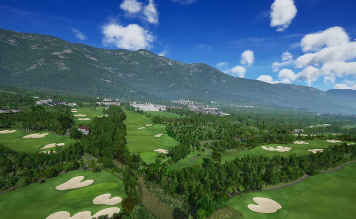 Aerial view of lush golf course with fairways, sand traps, forests, and mountain backdrop.
