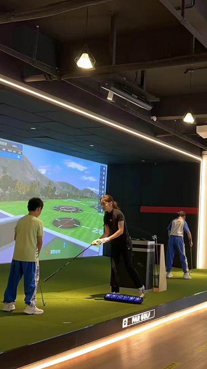 People playing a virtual golf game in an indoor facility.