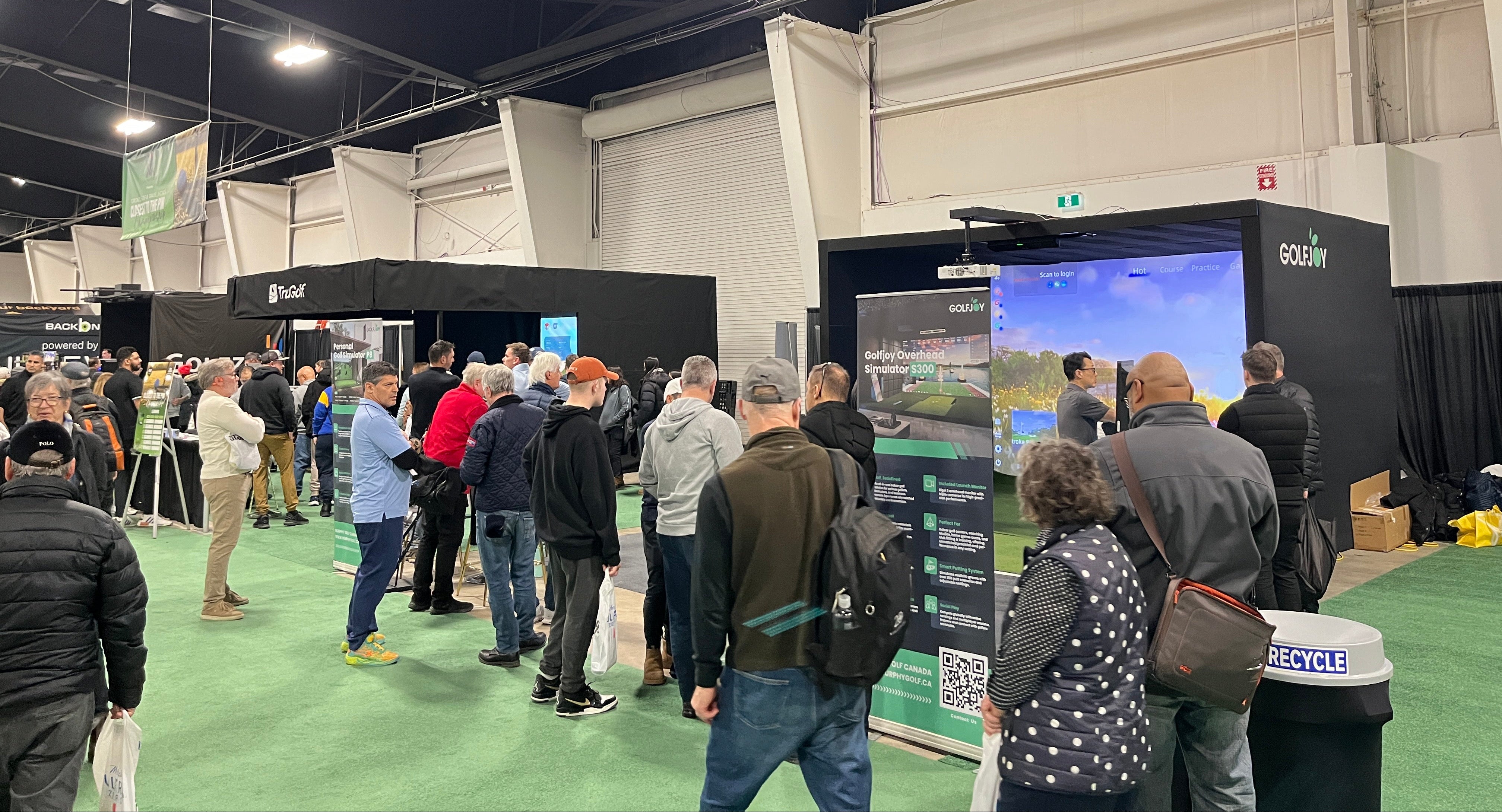 People gathered around a display at an indoor event or convention.